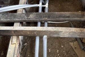 Lagged barrier pipe under floorboards during installation